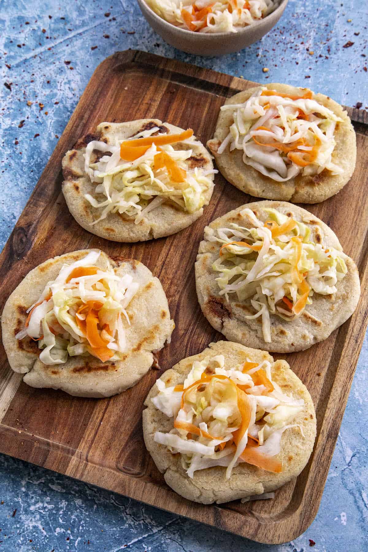 Plato de pupusas revueltas con curtido