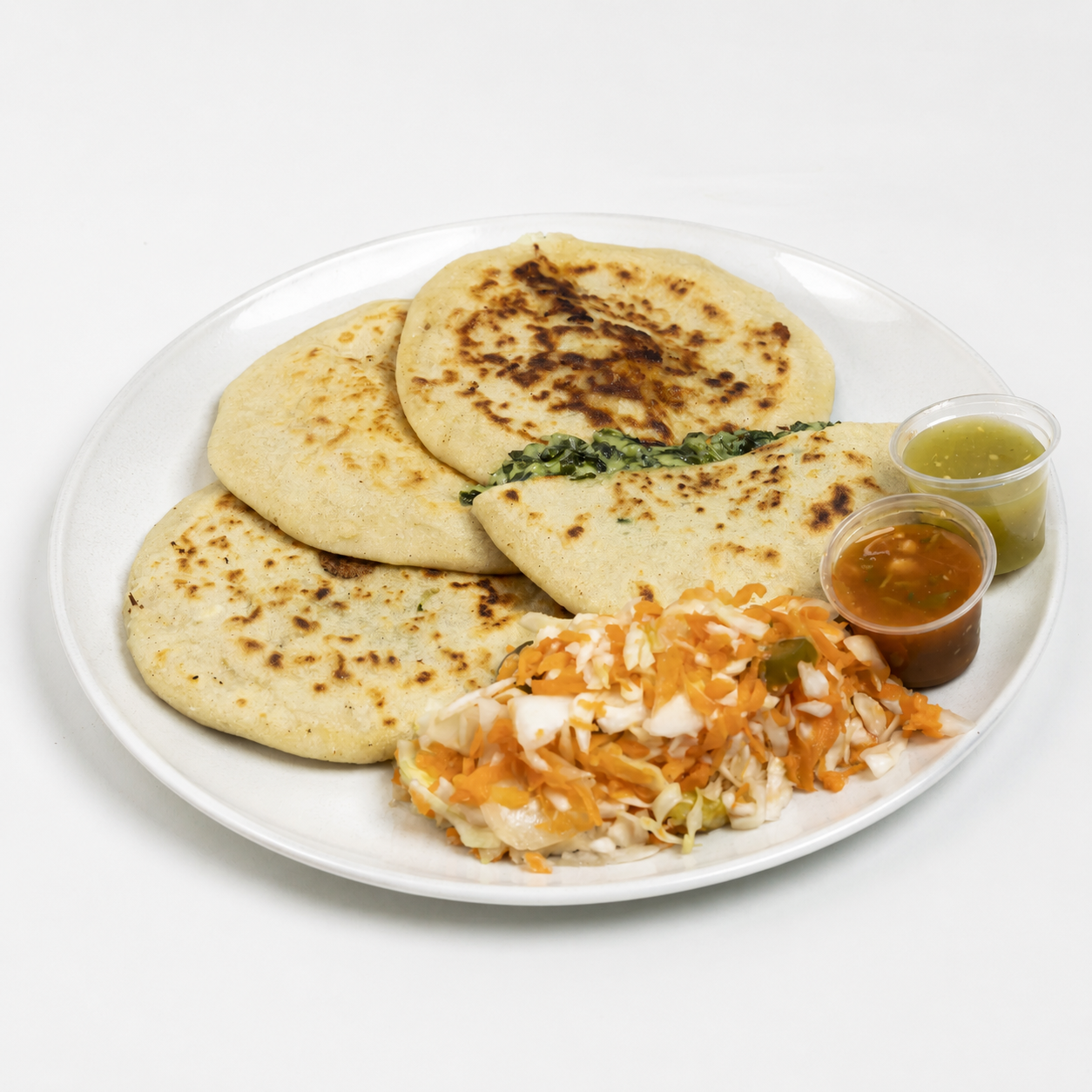 Plato de pupusas recién hechas al comal servidas con curtido de repollo y salsa roja