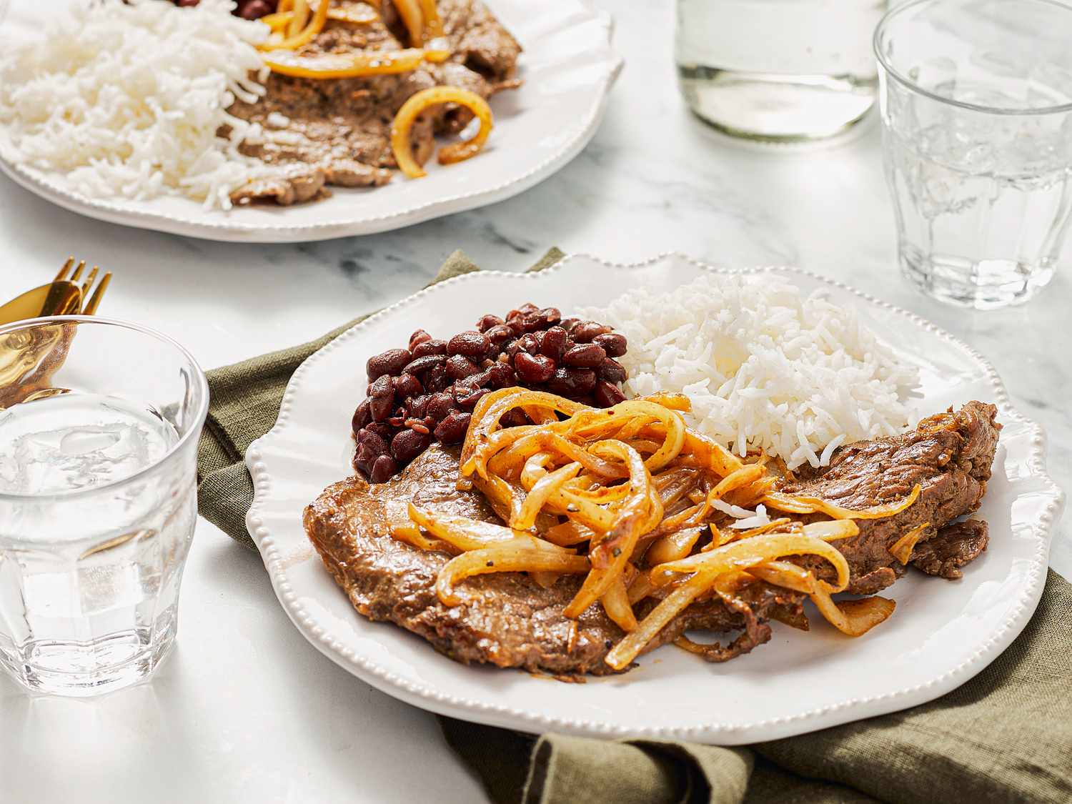 Bistec encebollado con arroz blanco y frijoles rojos